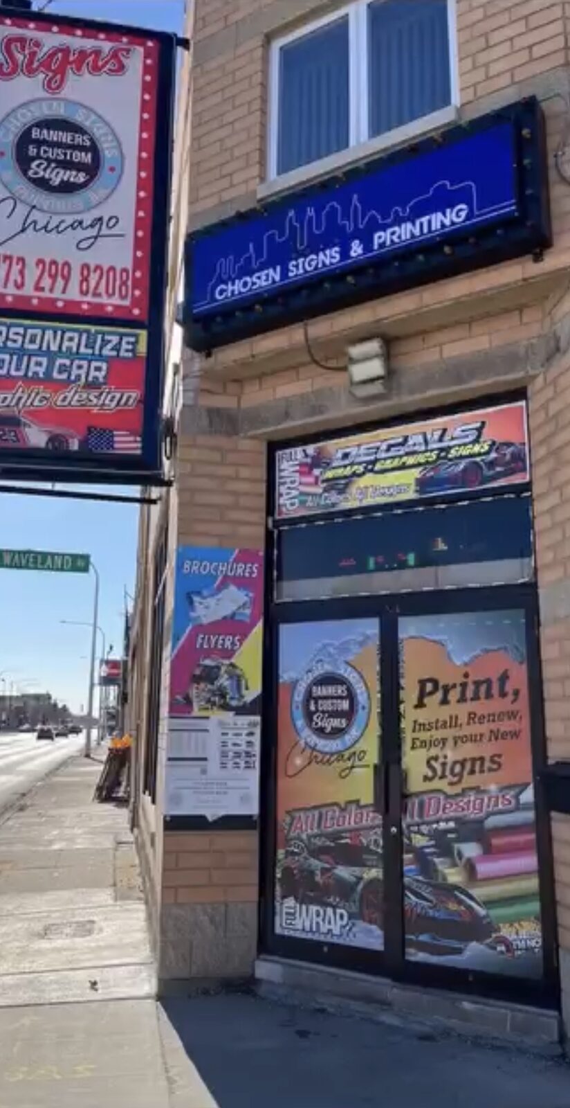 Chosen Signs and Printing storefront on Cicero Ave with lit blue sign and wrapped entry door