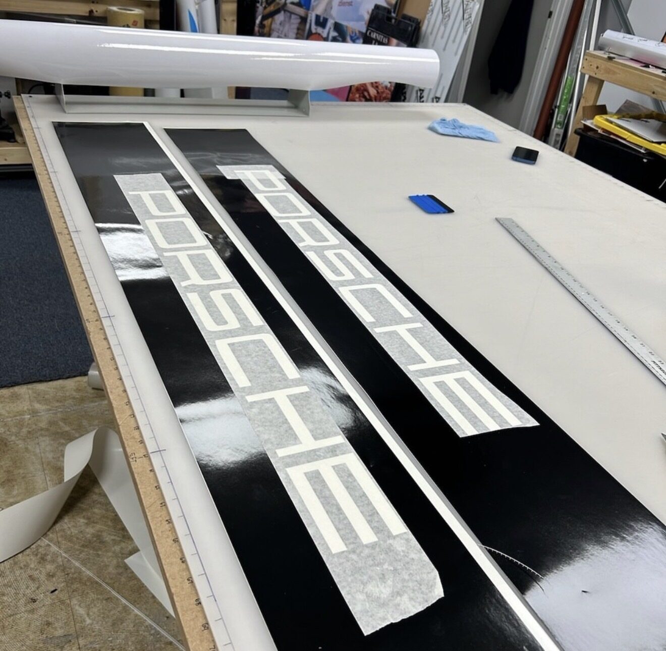 Cut vinyl Porsche lettering laid out on the work bench