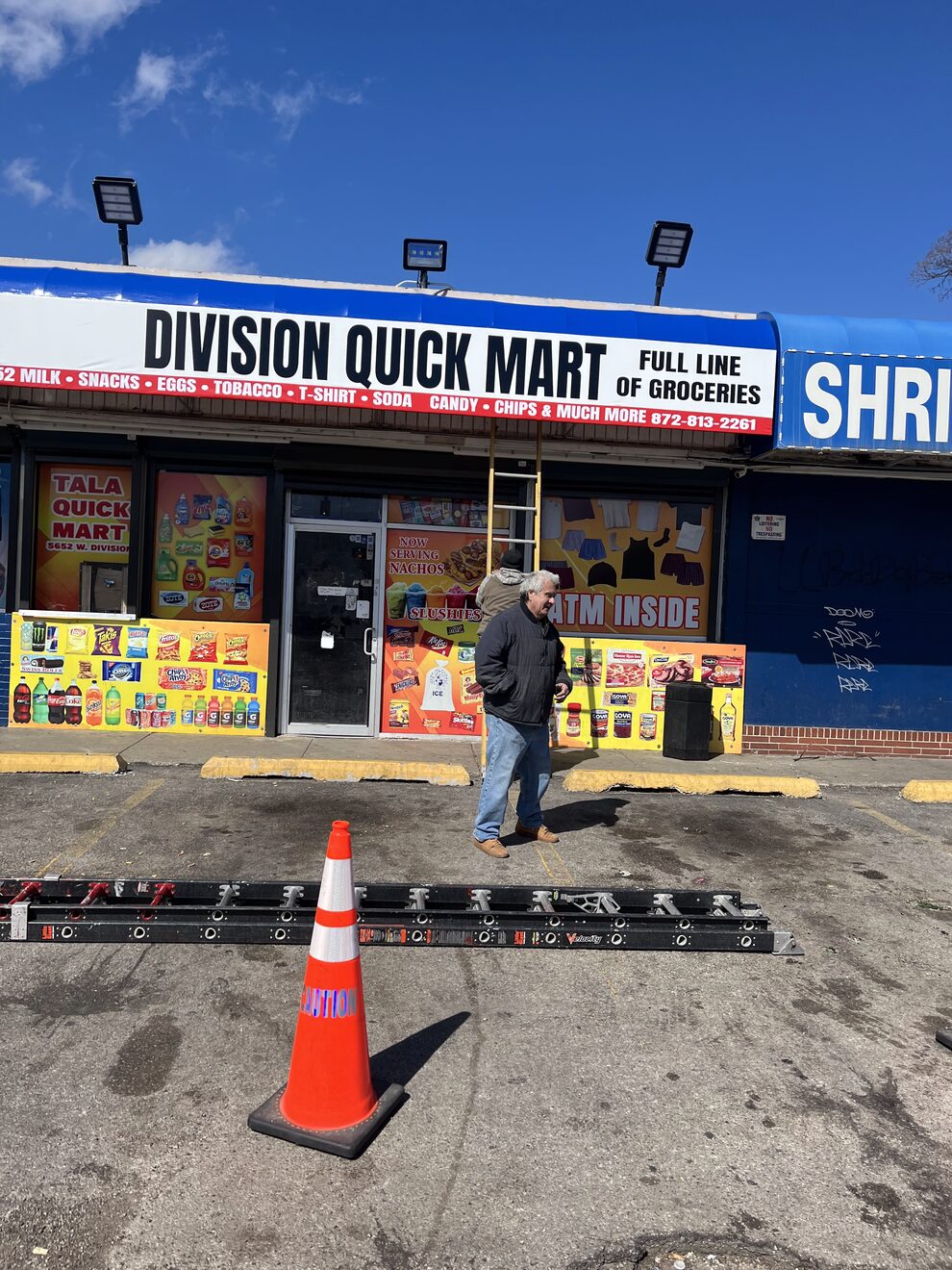 Division Quick Mart awning mounted above the storefront with the install ladder still out