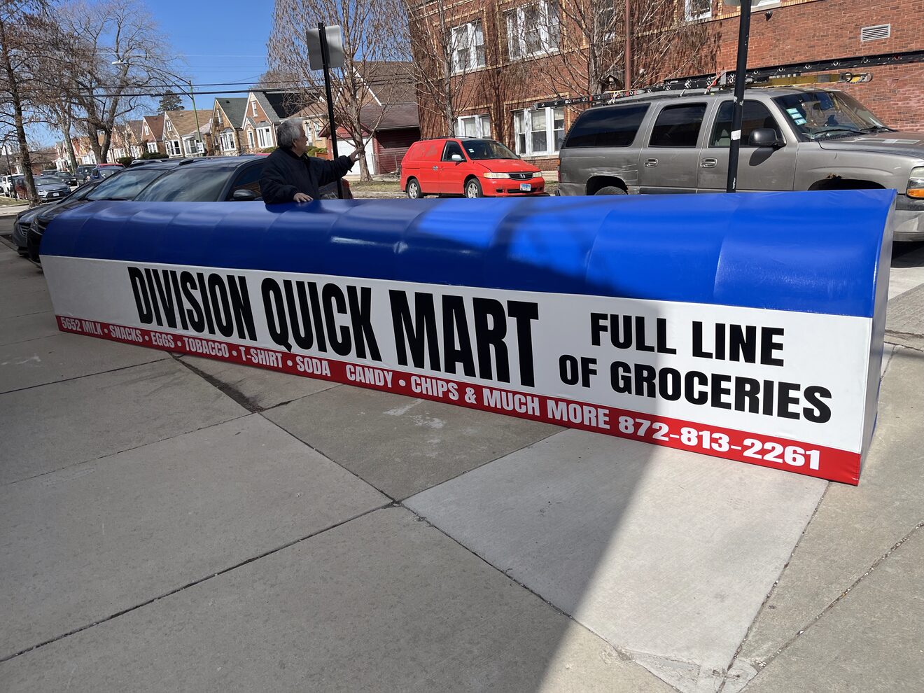 Finished blue and white Division Quick Mart awning on the sidewalk before install